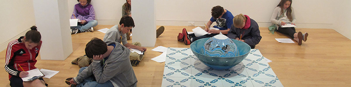 Group of students sit and work in the galleries at the Aldrich
