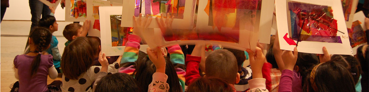 Young students hold up artwork they created
